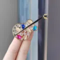 Chique gitaarvormige broche met sprankelende strass-steentjes en kleurrijke edelstenen. - Opengewerkte kattenoog gitaar broche