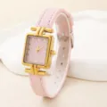 Detailansicht der Damenuhr, rosa Armband, goldenes T-Stück Quadratgehäuse, elegantes Zifferblatt. - Rosa