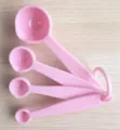 Gedetailleerd overzicht van roze plastic maatschepjes set met duidelijke capaciteitsaanduiding. - YL-302 Gescaleerde Maatlepel