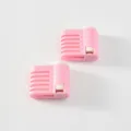 Gedetailleerd uitzicht op roze plastic taartsnijder en egaliseergereedschap met gleuven. - Roze Buitenkant Wit Binnenkant