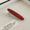 Detailaufnahme der roten Acetat-Haarspange mit glänzender Oberfläche und stabiler Metallklammer. - Retro Kupfer