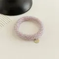 Detailansicht des helllila Kristallperlen Haargummis Armbands mit süßem Goldanhänger. - Kirschblütenrosa