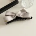 Satijnen strik haarklauw clip detail, elegante champagne haarspeld met zwarte kunststof tanden. - Abrikoos