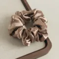 Brauner Satinhaarring mit funkelnden Strasssteinen, Detailansicht der feinen Textur. - Braun