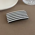 Nahaufnahme Detail der schicken schwarz-weißen Haarspange mit klaren geometrischen Linien. - Quadratische Klammer / Schwarz-weiße Streifen