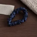 Nahaufnahme eines dunkelblauen reinen Seidenhaargummis mit zarter glänzender Textur. - S / Marineblau