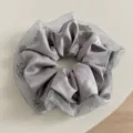 Vista detallada de un coletero de satén gris con borde de malla de cristal para el cabello. - Gris