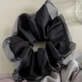 Primer plano del coletero de satén negro con volantes de organza y pedrería brillante. - Negro