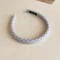 Vue détaillée du serre-tête en tissu à carreaux bleu et blanc, accessoire élégant. - Bleu à Carreaux