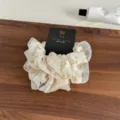 Nahaufnahme des zarten floralen Organzastoffes, die feine Blumenstrukturen zeigt klar. - Beige Serie