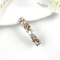 Detailed close-up of a luxury rhinestone and pearl hair clip with sparkling champagne crystals. - A-Style Champagne