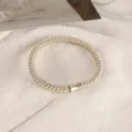 Detailed view of stylish braided hair tie with metal tube decor for daily ponytail styling. - Champagne