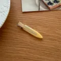 Minimalistische gelbe Entenschnabel Haarklammer Detailaufnahme, elegantes Accessoire. - Gelb