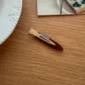 Nahaufnahme der minimalistischen braunen Entenschnabel-Haarspange aus Harz für elegantes Styling. - Braun