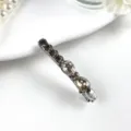 Crystal hairpin detail view featuring sparkling dark rhinestones on a sleek metal barrette base. - Style 2 Grey