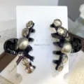 Detailed close-up of a pair of black hair claw clips decorated with rhinestones and bows. - Pearl Style / Pearl Style in Grey with Black Base