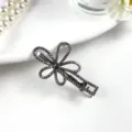 Close-up detail shot of a sparkling rhinestone hairpin on white background with pearl props. - Bestseller A