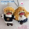 Close-up van handgemaakte notendop koppel pop hangers met krullend haar en gebreide trui details. - Meisjesmodel met bruin haar voor koppels