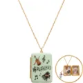 Detailed close-up view of vintage music theme locket necklace showing open interior. - Music Scene / Gold
