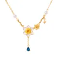Detailopname van de vergulde decemberbloemketting met geëmailleerde narcishanger en blauwe steen. - December Geboortebloem