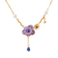 Gedetailleerd close-up van vergulde ketting met paarse emaille bloemen en blauwe hanger. - September Geboortebloem
