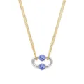 Gros plan d'un collier en chaîne dorée avec pendentif argenté et perles en porcelaine. - Style Ovale Épissé à Couches / Acier et Or Épissé