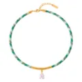 Detalle en primer plano del collar de cordón trenzado con tubo dorado curvo y colgante lágrima. - Estilo Gota de Agua Cuerda Verde