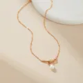 Detailed view of gold plated necklace with small beads and elegant bow knot pearl pendant design. - Knot Water Drop Bead Style