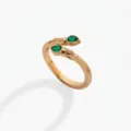 Primer plano de un elegante anillo de serpiente dorado de dos cabezas con piedras de circonita verde. - Anillo abierto / Mayo