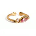 Vista detallada de anillo abierto dorado minimalista con piedras redondas y rosas brillantes. - Anillo de Octubre