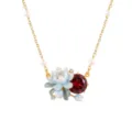 Exquisite flower necklace detail featuring enamel lotus pendant, pearls and sparkling red stone. - January Birth Flower