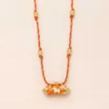 Detailed view of the stylish orange braided cord necklace featuring gold beads and a cylinder pendant. - Lamb
