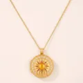Nahaufnahme der vergoldeten Sonnen Medaillon Halskette mit Perlen und Steindetail. - Gold Sonnenmuster Stil