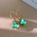 Detail view of bohemian resin teardrop earrings featuring dried green flowers inside. - Ear Hook Gold Green / Green