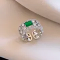 Exquisite emerald-cut green cubic zirconia open ring with intricate filigree and sparkling side stones. - No. 18 Open Rings - Silver and Green