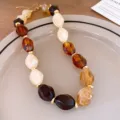 Close-up detail of the European fashion acrylic geometric beaded necklace with luxury style. - Necklace / Brown