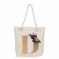 Canvas tote bag detail with large gold letter D and elegant vintage floral graphic. - Golden Letter D Print Style