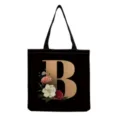 Black canvas tote bag detail featuring a golden letter B and vintage floral print. - Letter B Print (hm3236)