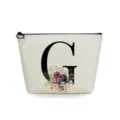 Close-up detail of the canvas makeup pouch featuring a elegant floral letter G print. - Letter G Style