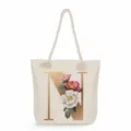 Close-up detail of the canvas tote bag featuring a large golden initial N and floral print. - Golden Letter N Print Style