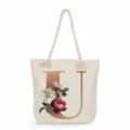 Canvas tote bag detail showing gold letter U print, vintage floral design and rope handle. - Golden Letter U Print Style