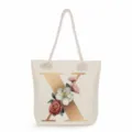 Detail view of the canvas tote bag featuring a gold letter X and delicate floral print. - Golden Letter X Print Style