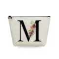 Close-up detail of canvas makeup bag featuring elegant letter M and floral print design. - Letter M Style