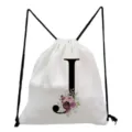 Minimalist white canvas drawstring backpack featuring a black letter J and floral print detail. - Letter J Style
