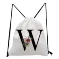 White drawstring backpack detail featuring a stylish black letter W and floral print design. - Letter W Style