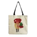 Detail view of canvas tote bag featuring stylish red dress illustration and black shoulder straps. - Fashion Woman Back Rose Illustration Print(hm3365)