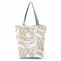 Minimalist canvas tote bag featuring stylish tiger print pattern with durable grey handles. - Gold Tiger Head Print (hl2693)