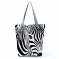 Close-up of the artistic zebra pattern print and fabric texture on the casual canvas tote bag. - Zebra Stripe And Eye (hl2697)