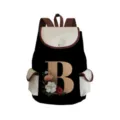 Close-up detail of canvas backpack featuring floral letter B print and brown leather trim. - Black Letter B Style