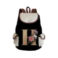 Detailed view of black canvas backpack with letter H floral print, brown straps and pocket. - Black Letter H Style